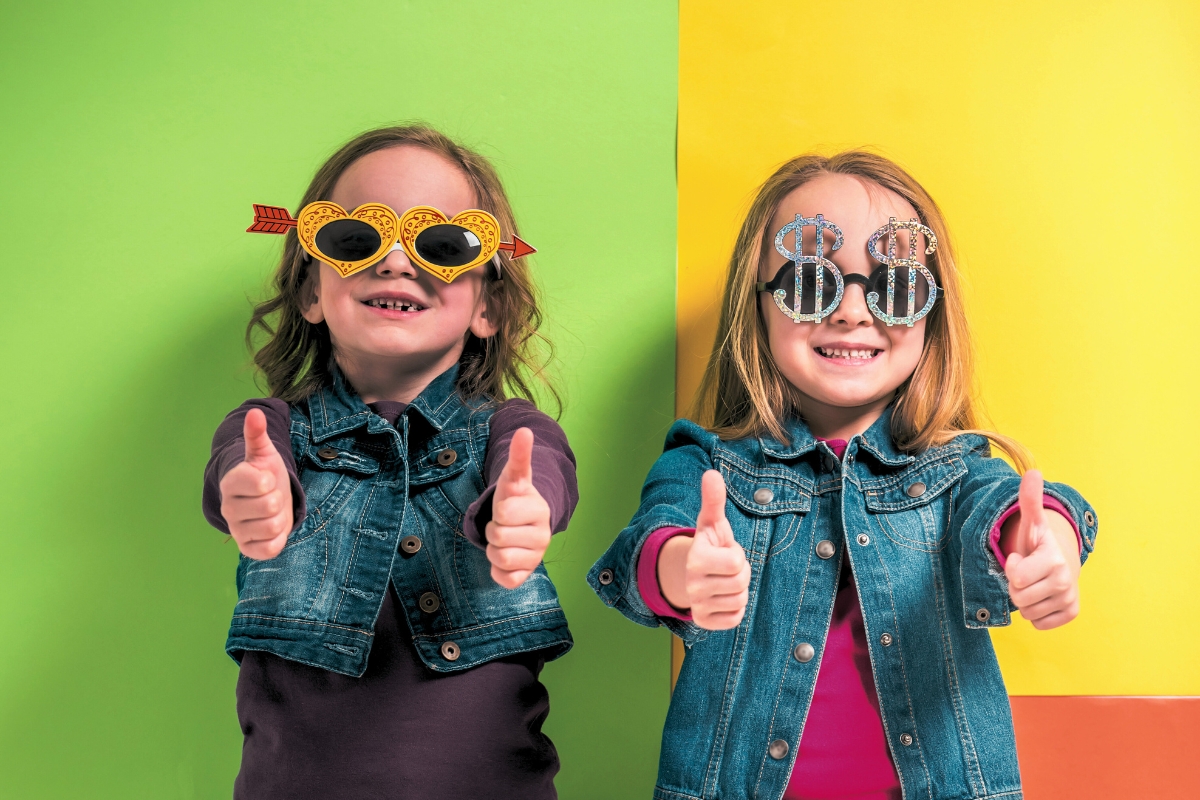 two little girls giving thumbs up with sunglasses and