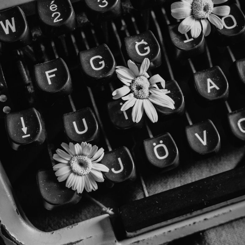 Vintage typewriter with flowers sprouting from the keys