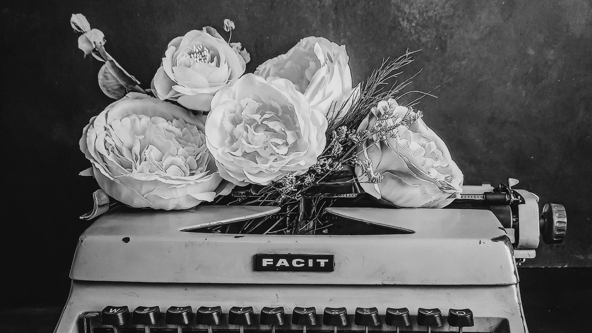 Vintage typewriter with wildflowers growing through the keys, symbolizing resilience and truth